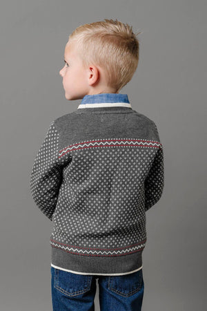A boy wearing a charcoal heather sweater with an ivory birdseye pattern stands against a gray background.