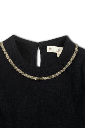 Close-up of a black sweater dress by Hope & Henry, featuring a gold-tipped collar and a back neck button closure. Made from soft organic cotton, perfect for toddlers and kids.