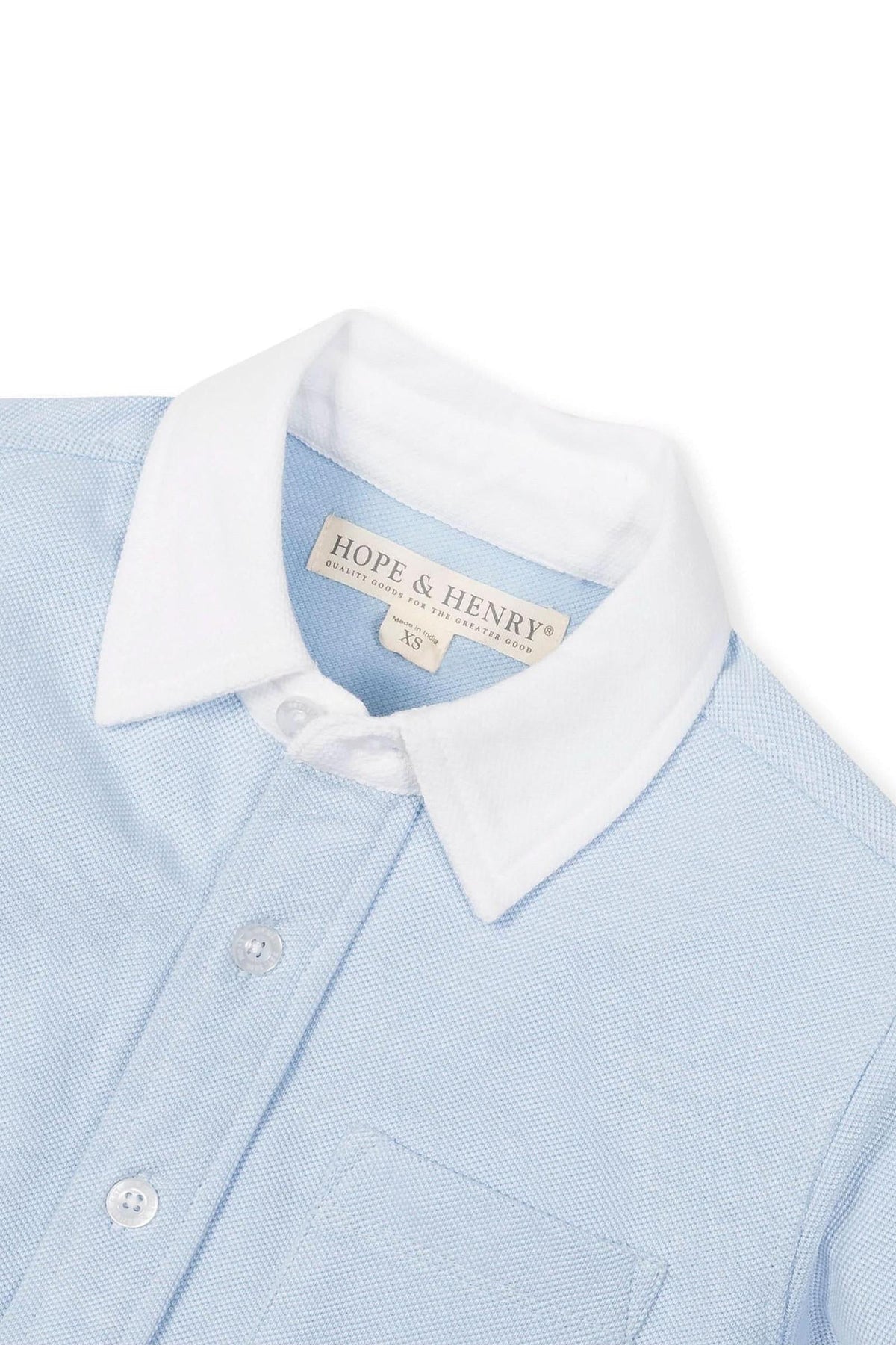 Light blue pique cotton button-down shirt by Hope & Henry features a classic white collar and front pocket. Designed for ages 2T-10, it emphasizes sustainable and quality materials.