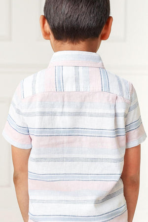 A young boy is seen from the back, wearing a short-sleeve, striped button-down shirt in soft pastel colors.