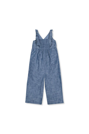 Chambray jumpsuit with ruffle neck detail, smocked back, and wide legs, made from soft organic cotton for toddlers.