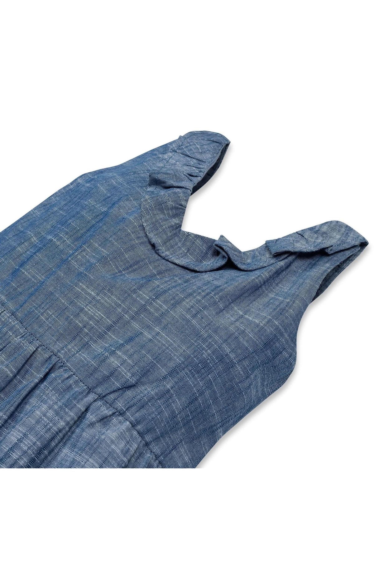 Close-up of a blue chambray jumpsuit featuring a ruffled neckline and soft organic cotton material, designed for toddlers and kids.