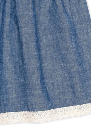 Close-up of a chambray dress featuring delicate white crochet trim along the hem, showcasing soft organic cotton fabric.