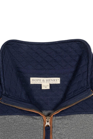 Close-up view of a Hope & Henry organic cotton pullover featuring a navy mock neck and half zip, with a diamond quilted pattern around the yoke and faux suede piping.