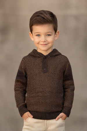 A young boy smiles while wearing a chocolate brown hooded sweater with a henley placket, set against a neutral background.