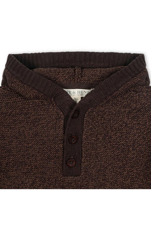 Close-up of a chocolate brown hooded henley sweater featuring a ribbed collar and three brown buttons. Made from organic cotton.