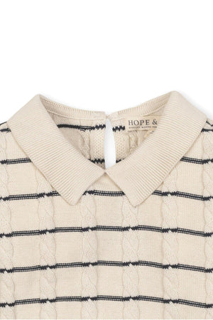Close-up of an ivory cable knit sweater dress featuring a Peter Pan collar and navy Breton stripes, labeled Hope &.