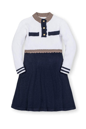 A girls sweater dress by Hope & Henry, featuring a white ribbed top with a mock neck and navy skirt. Made from soft organic cotton, it’s perfect for cooler weather.