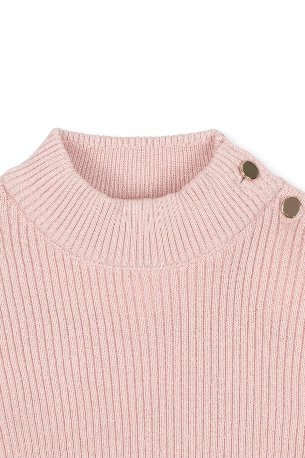 Close-up of a soft pink organic cotton mock neck sweater featuring ribbed knit and decorative buttons on the shoulder.