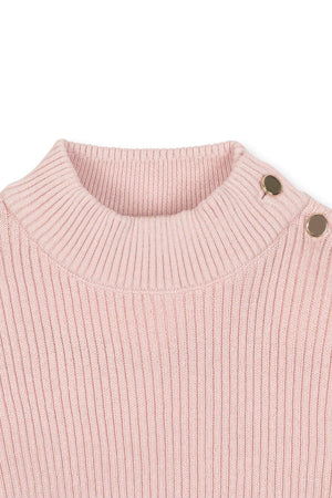 Close-up of a soft pink organic cotton mock neck sweater featuring ribbed knit and decorative buttons on the shoulder.