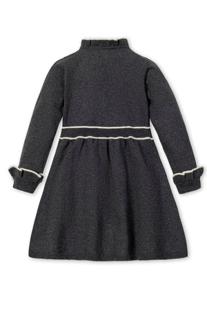 Back view of a charcoal gray sweater dress featuring long sleeves, ruffled cuffs, and a contrasting white waistband detail.