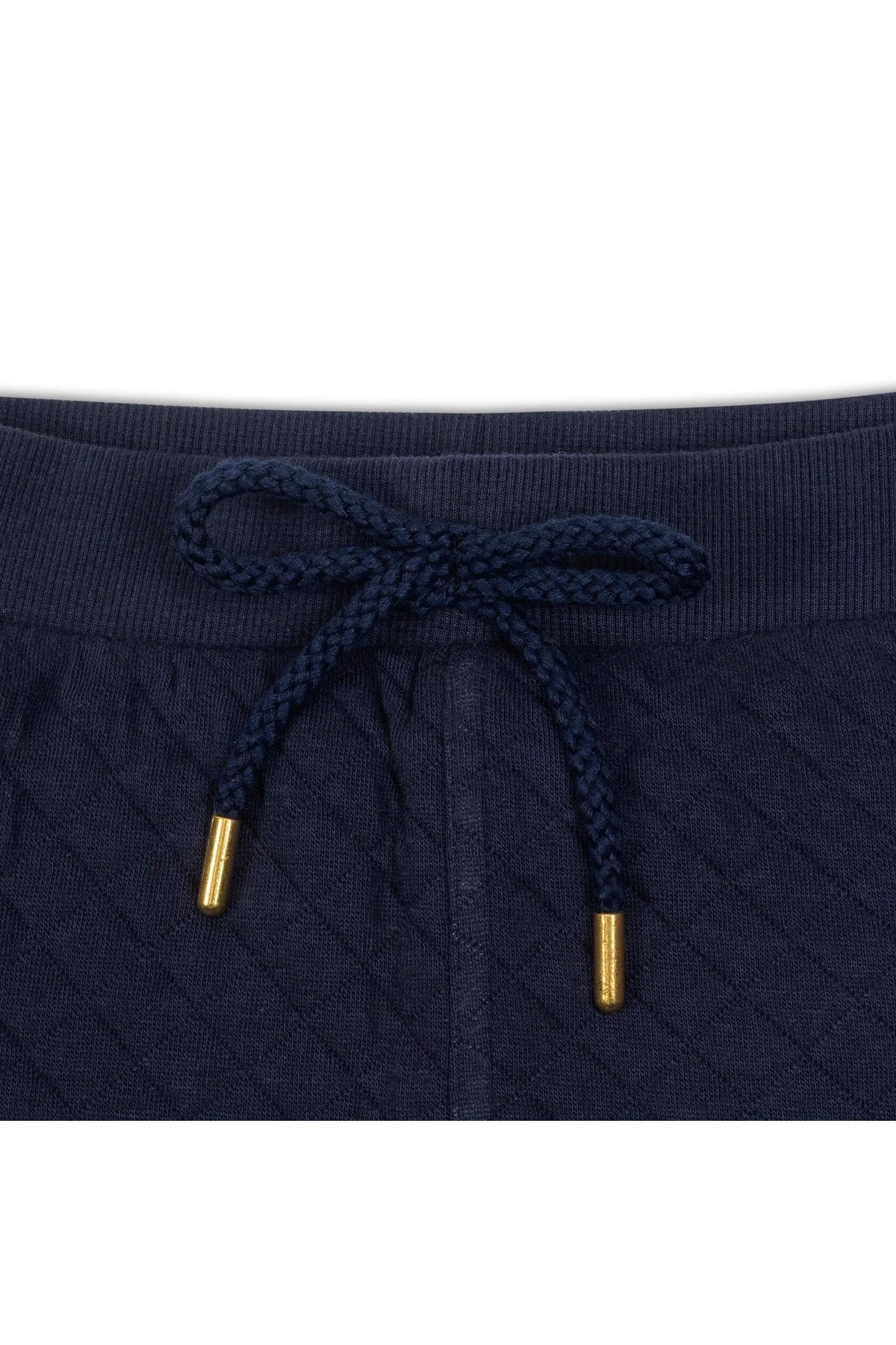 Close-up of a navy quilted waistband featuring a braided drawcord with gold metal tips, showcasing soft organic cotton material.