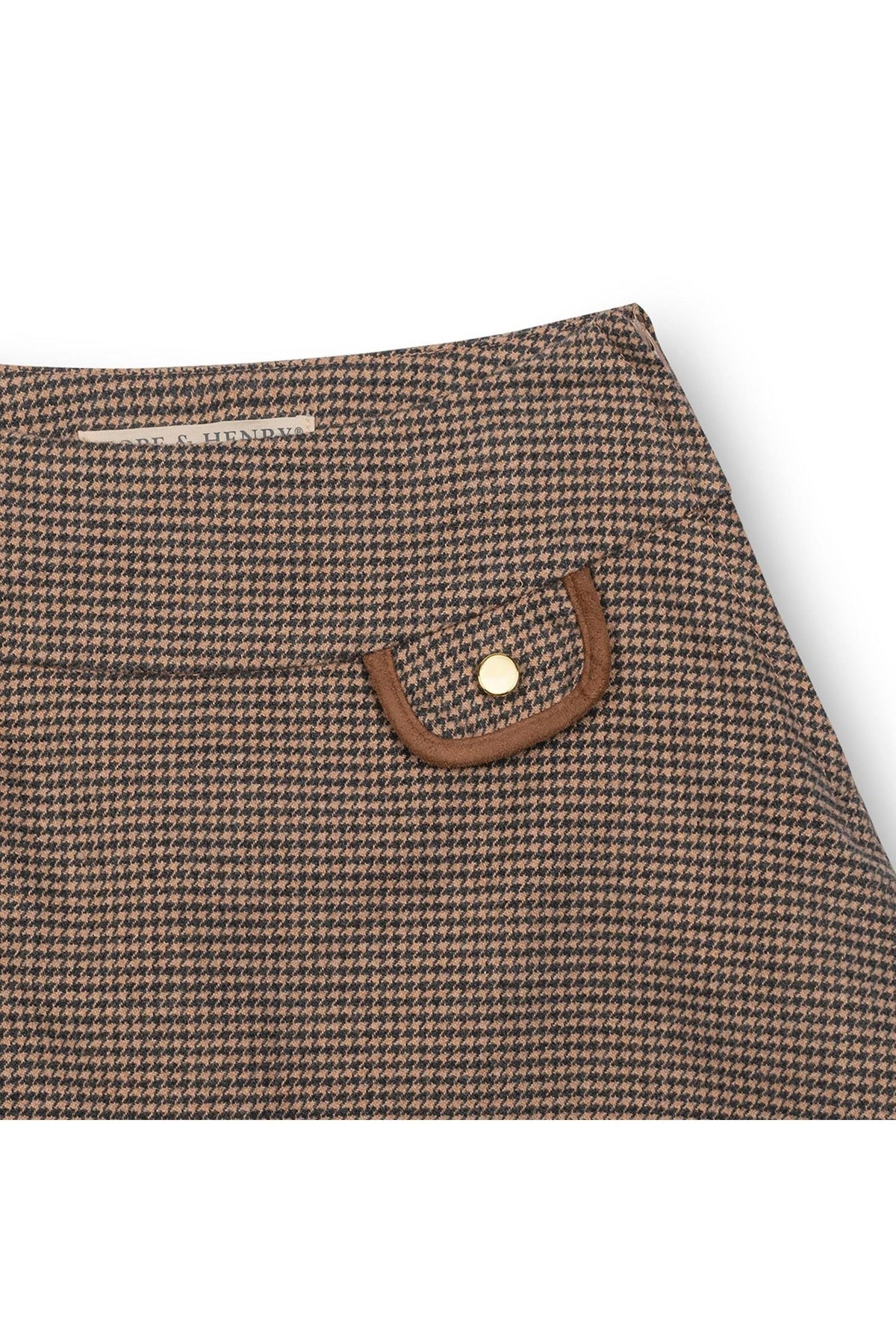 Close-up of a brown houndstooth patterned fabric featuring a decorative flap pocket with a gold button, designed for childrens wear.