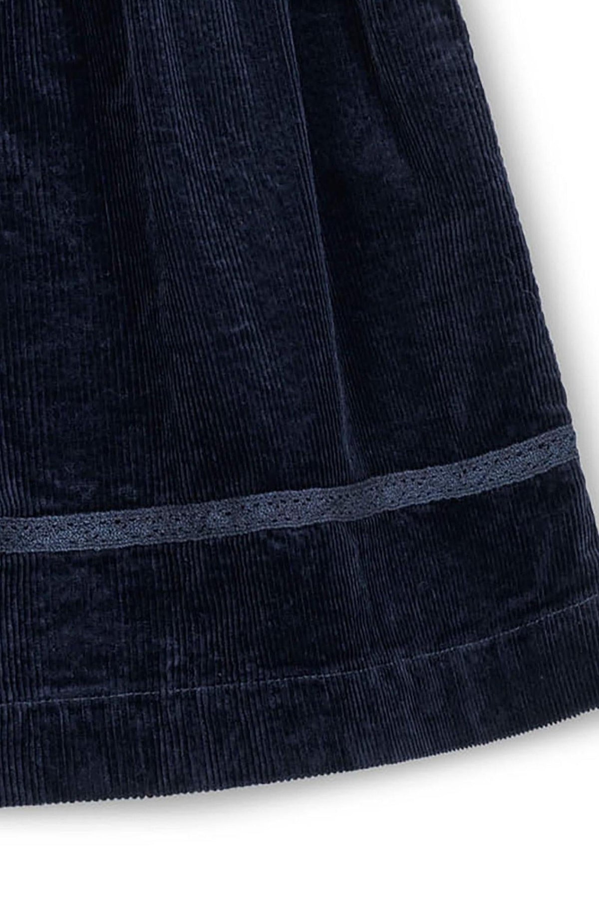 Close-up of a navy corduroy fabric showing a crochet trim and textured pattern, ideal for a toddlers jumper dress.