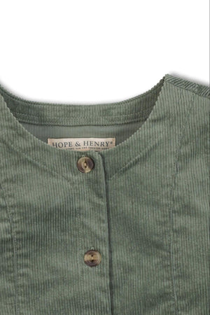 Close-up of a sage green corduroy jumper dress by Hope & Henry, featuring a round neckline and a single button.