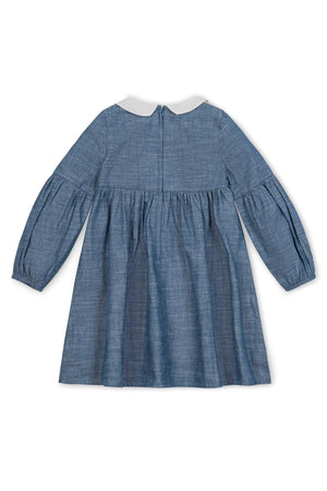 Back view of a chambray dress featuring a white Peter Pan collar and gently puffed sleeves. The dress has an empire waist and a zipper closure for easy dressing.
