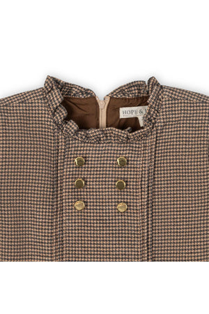 Close-up of a beige and grey houndstooth dress featuring a ruffle collar and gold buttons, labeled HOPE & HENRY.