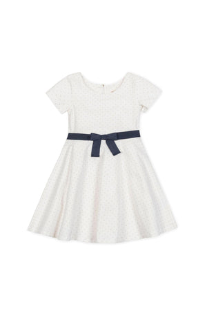 White short sleeve skater dress with pindot pattern and a navy bow at the waist, suitable for kids.