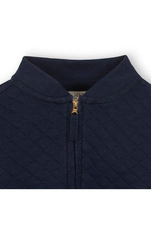 Close-up of a navy blue quilted bomber jacket collar featuring a gold zipper and ribbed trim for a stylish look.