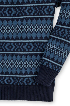 Close-up of a navy and steel blue patterned sweater featuring a Fair Isle design and ribbed cuffs.