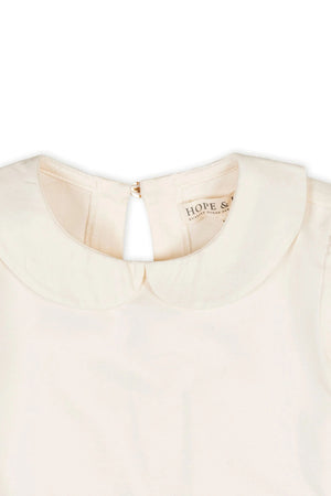 Close-up of an ivory knit top featuring a Peter Pan collar and a keyhole neck closure, labeled Hope & Henry.