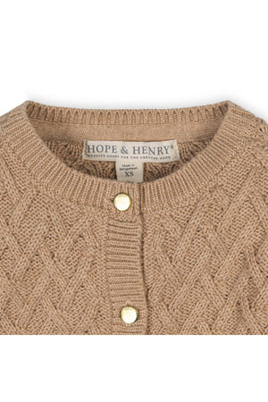 Close-up of a camel-colored organic cotton cardigan by Hope & Henry, featuring a herringbone cable knit pattern and gold shank buttons.