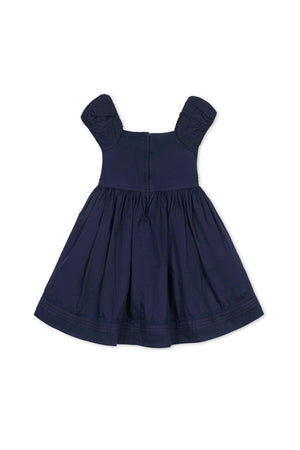 Navy organic cotton dress with puff sleeves and pintuck bodice, featuring a full skirt and delicate embroidered hem.