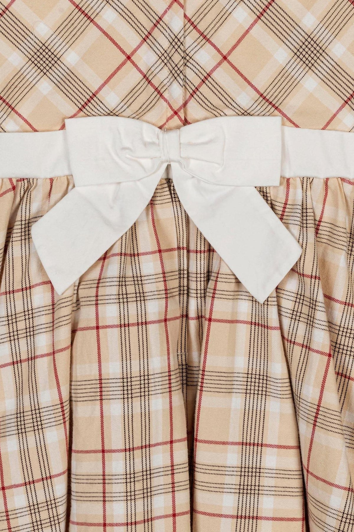 Close-up of an ivory fireside plaid dress featuring a white bow belt, showcasing structured fabric and classic design elements.
