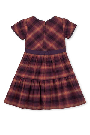 Back view of a tiered flannel dress in sugar plum plaid, featuring puff sleeves and a coordinating waistband.