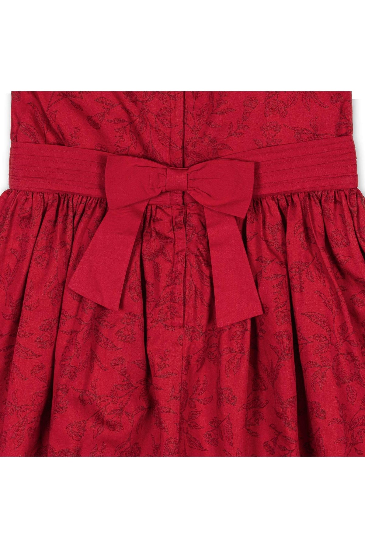 Close-up view of a rich fireside red dress featuring a textured toile pattern, with a tailored bodice and a matching sash tied in a bow at the waist.