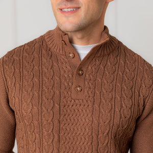 A close-up of a man wearing a cinnamon heather mock neck cable sweater made from organic cotton.