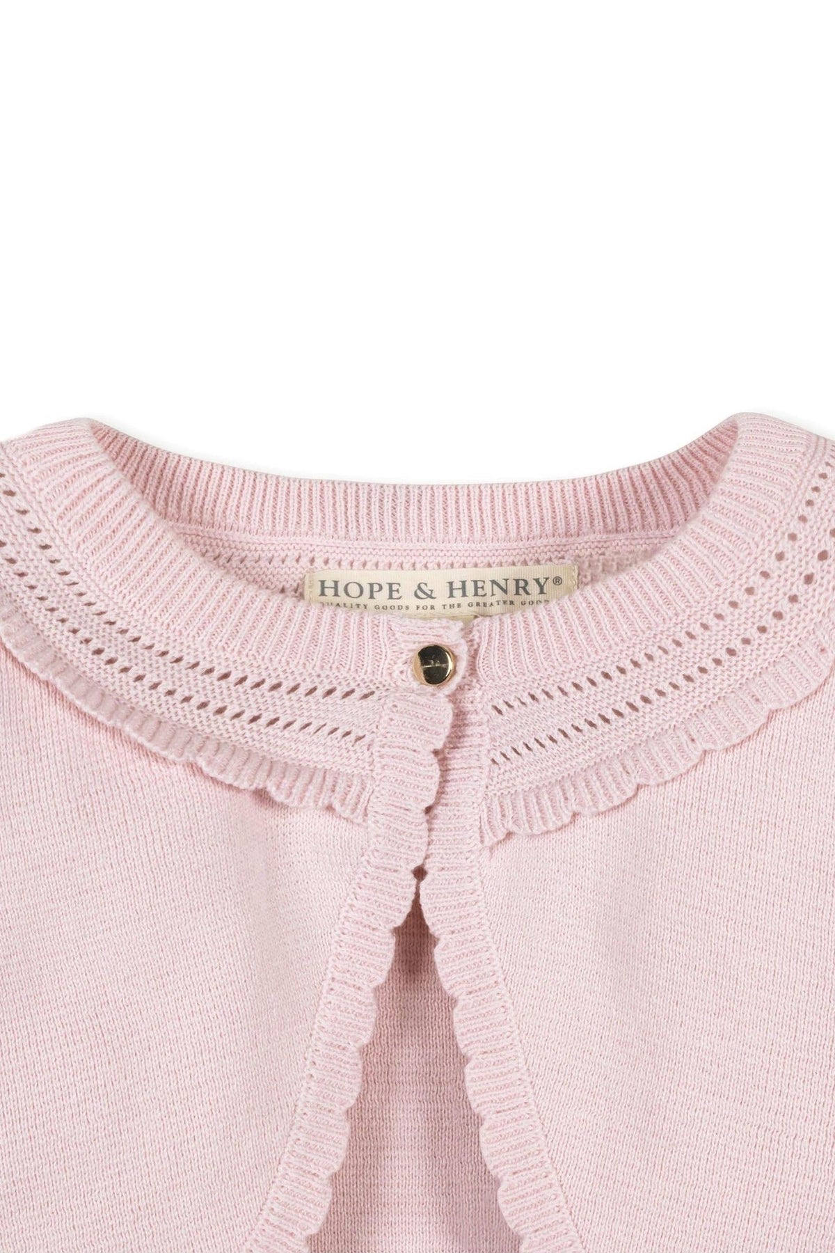 Close-up of a pink Hope & Henry organic cotton cropped cardigan featuring a delicate pointelle pattern and pearlized buttons.