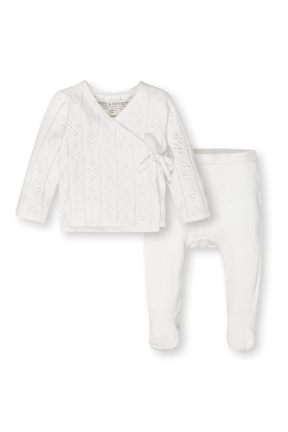 White organic cotton baby sweater and footed leggings set by Hope & Henry with pointelle detail and side-tie closure.