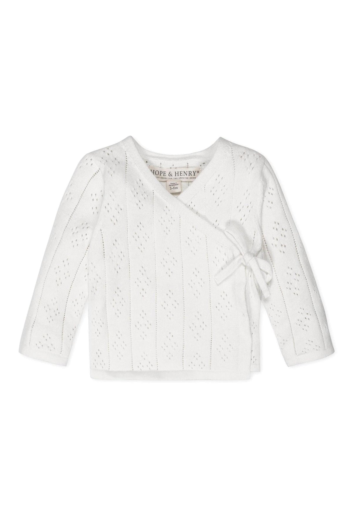 White organic cotton baby sweater with pointelle pattern and side-tie closure, by Hope & Henry.