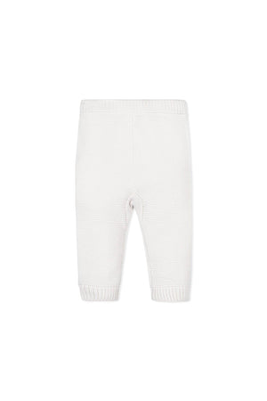 Organic cotton baby leggings in a soft cream color feature a textured knit design and ribbed cuffs.