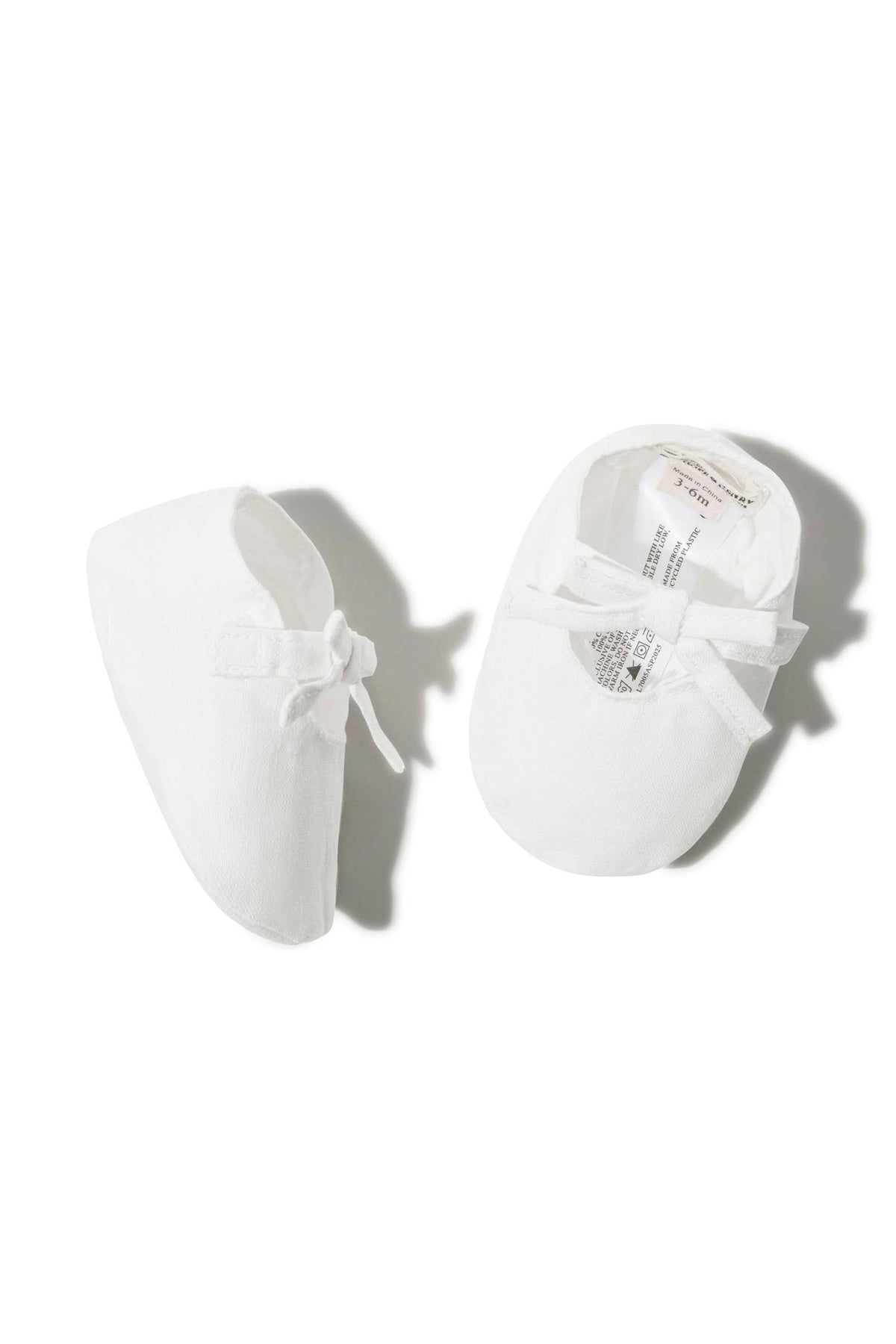 White linen baby shoes with a decorative bow, designed for infants aged 0-12 months. Soft and stylish, perfect for delicate.