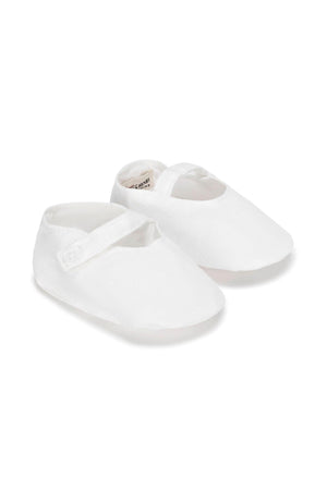 White linen baby shoes feature a button strap closure, perfect for infants up to 24 months. Ideal for various outfits.