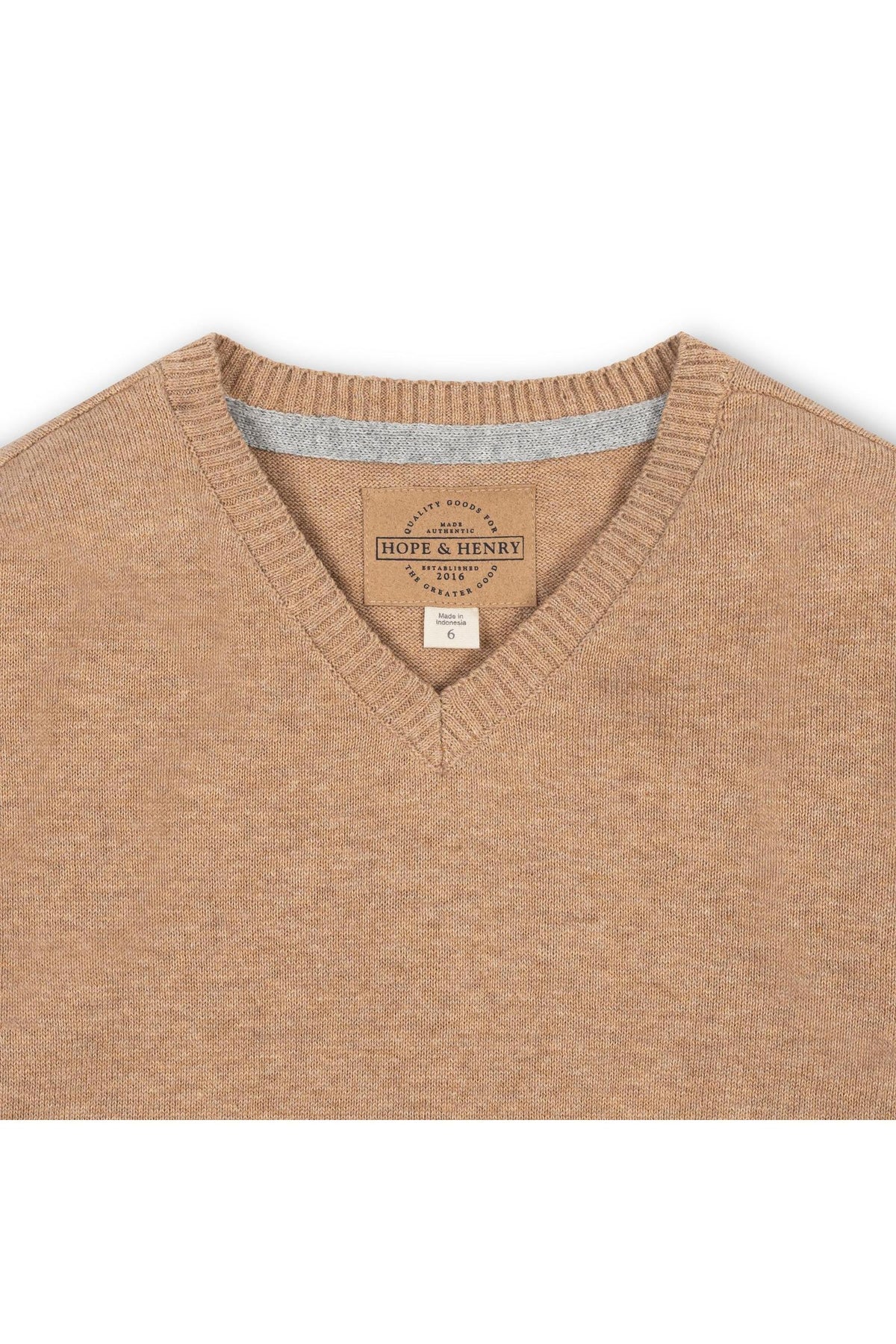 A close-up view of a camel-colored organic cotton V-neck sweater featuring a label from Hope & Henry. The soft fabric showcases a fine gauge knit, ideal for comfortable layering.