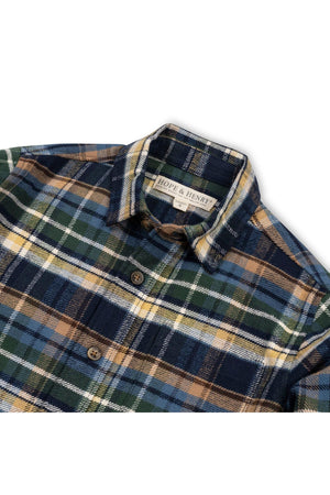 A close-up of a navy plaid flannel shirt by Hope & Henry, featuring earthy tones of green, yellow, and blue.