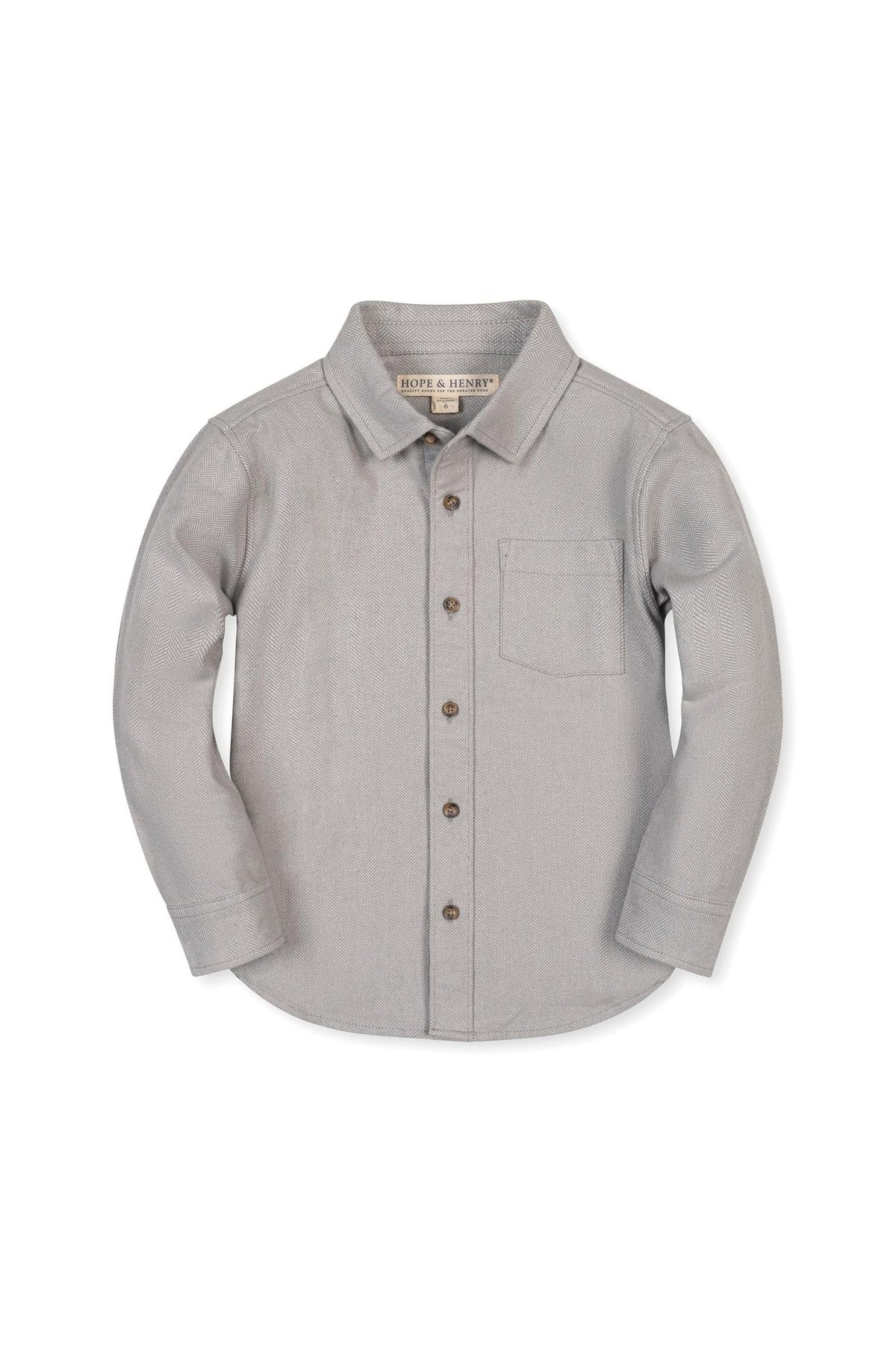 A soft grey organic cotton flannel shirt features a button-down front, collar, and single chest pocket. Designed for children, it combines comfort with sustainable materials for lasting wear.