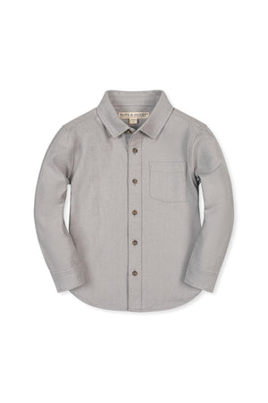 A soft grey organic cotton flannel shirt features a button-down front, collar, and single chest pocket. Designed for children, it combines comfort with sustainable materials for lasting wear.