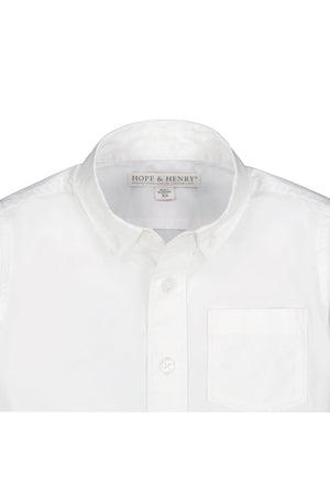 A close-up of a white button-down shirt by Hope & Henry features a classic collar and a single chest pocket, made from soft, breathable organic cotton suitable for boys.