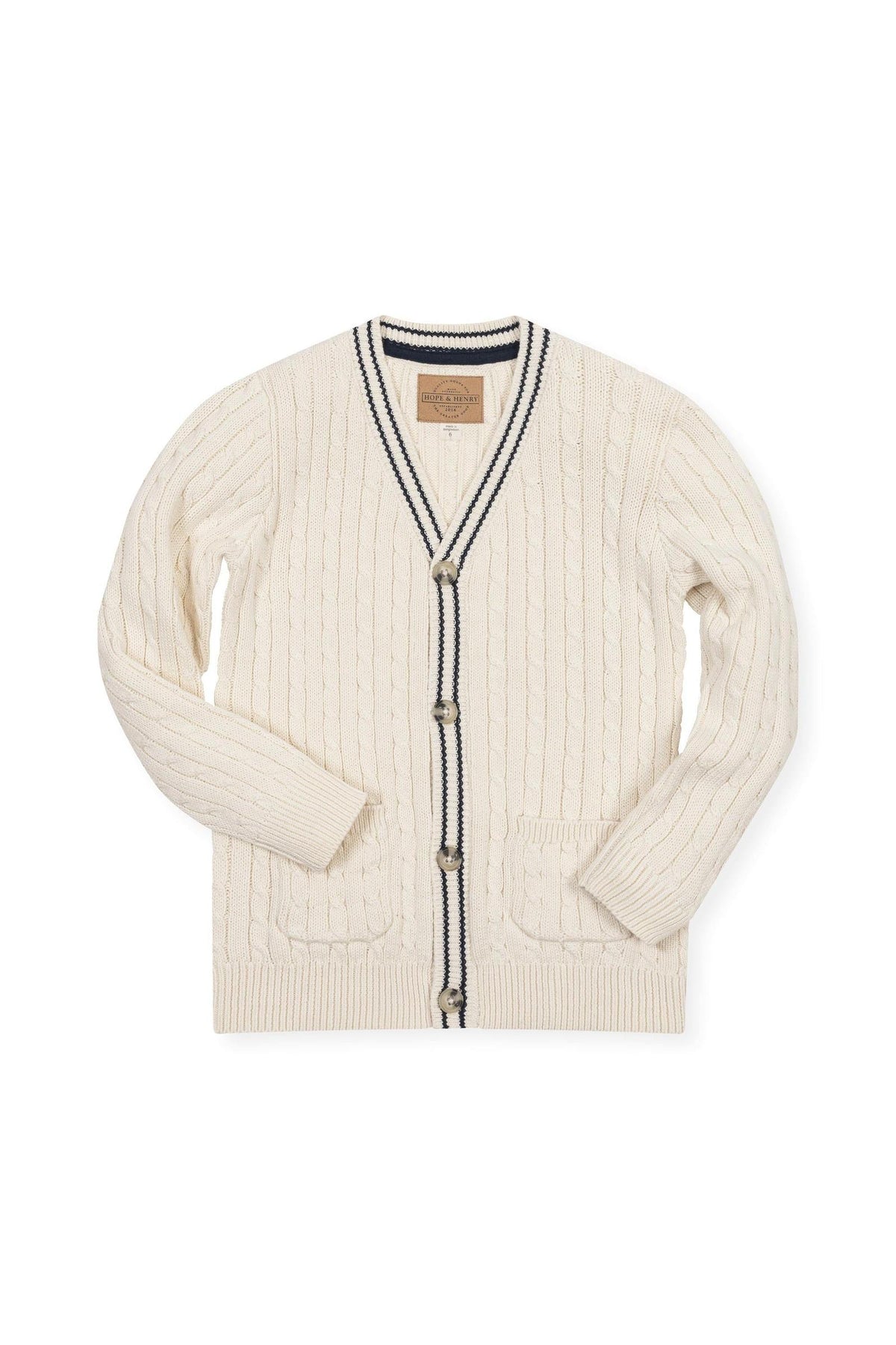Ivory organic cotton cable cardigan featuring a classic cable knit design, button closures, and contrasting navy trim. Perfect for boys aged 2T to 18/20, offering both style and comfort.