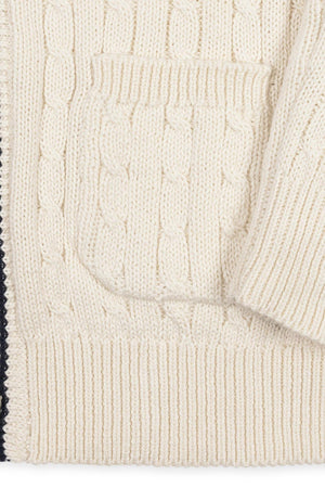 Close-up of an ivory organic cotton cable cardigan featuring a textured knit pattern and a patch pocket. Ideal for boys sizes 2T to 18/20, it offers cozy, sustainable comfort.
