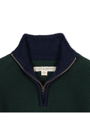Close-up view of a navy and green half zip sweater with a mock neck, featuring a textured knit design.