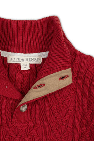 A close-up of a red mock neck cable sweater featuring a textured knit design, with a buttoned collar and a label reading Hope & Henry, sized for children.