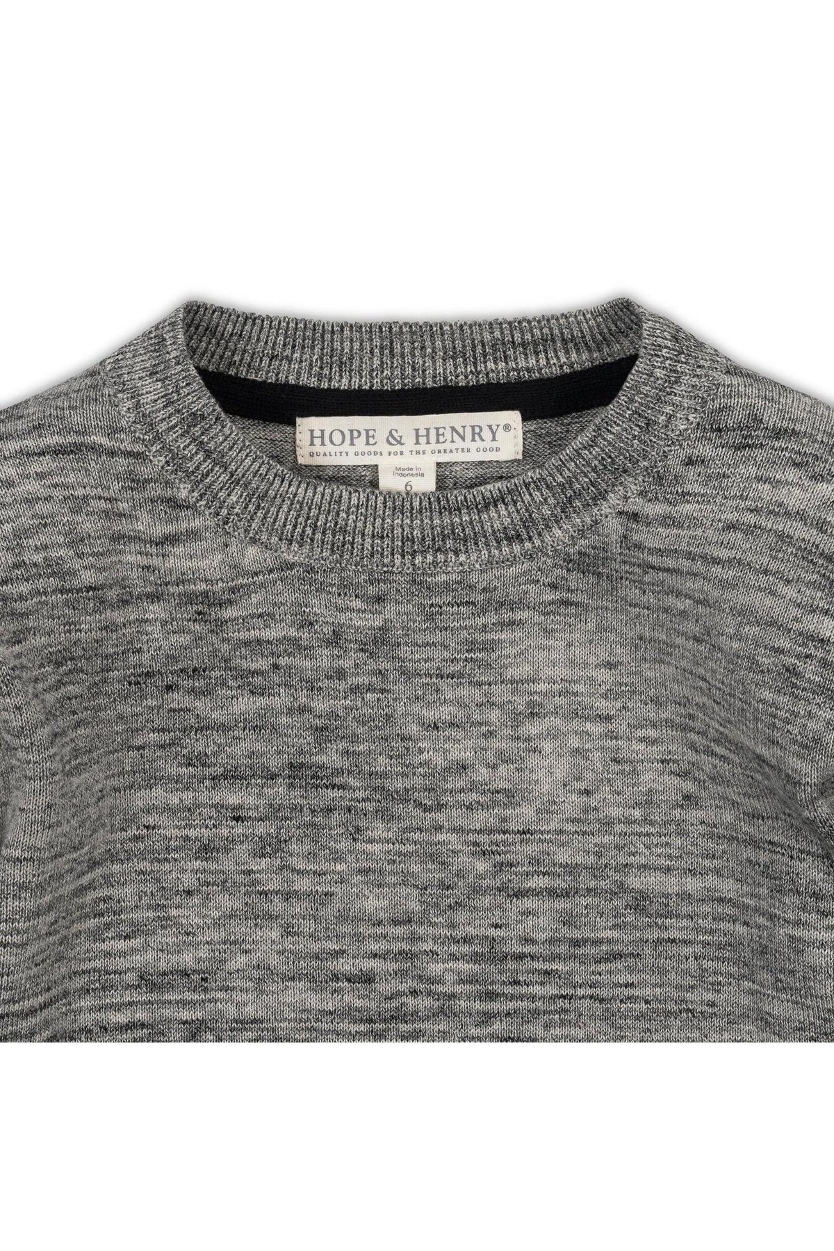 Close-up of a gray crewneck sweater made from organic cotton, featuring a soft texture. The label reads Hope & Henry, emphasizing its sustainable and eco-friendly qualities.