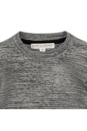 Close-up of a gray crewneck sweater made from organic cotton, featuring a soft texture. The label reads Hope & Henry, emphasizing its sustainable and eco-friendly qualities.