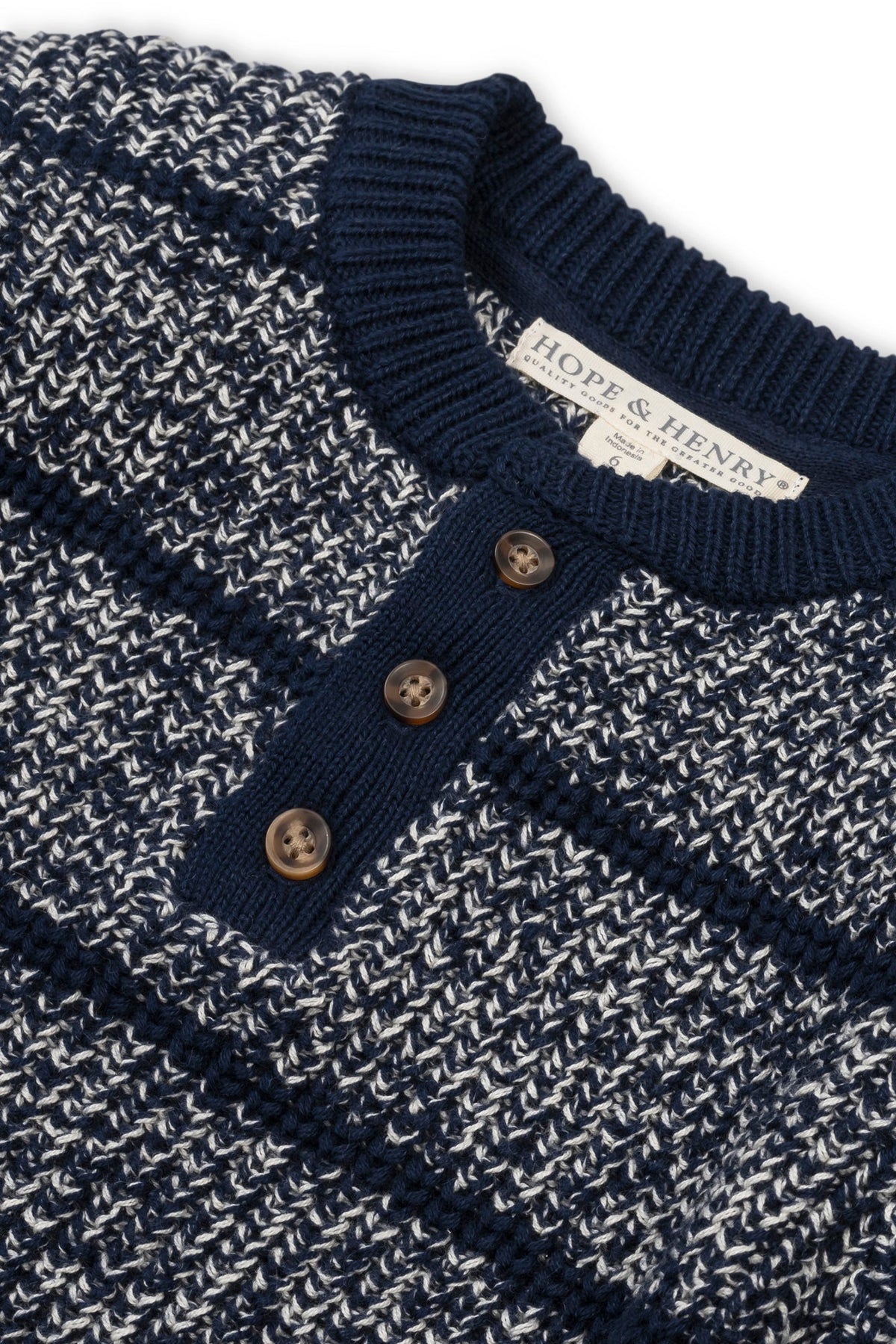 A navy organic cotton henley sweater features a textured knit design with contrasting stripes. The shirt includes three wooden buttons and a classic crew neckline, suitable for boys sizes 2T.