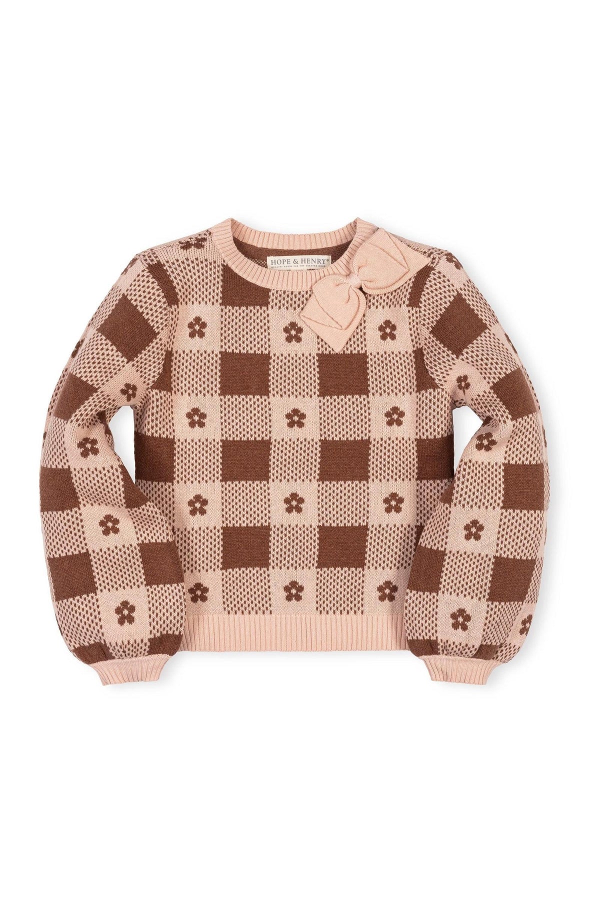 Light pink sweater featuring a checkered intarsia design in warm brown hues. The cozy garment includes a decorative bow detail and is made from soft, GOTS Certified organic cotton.